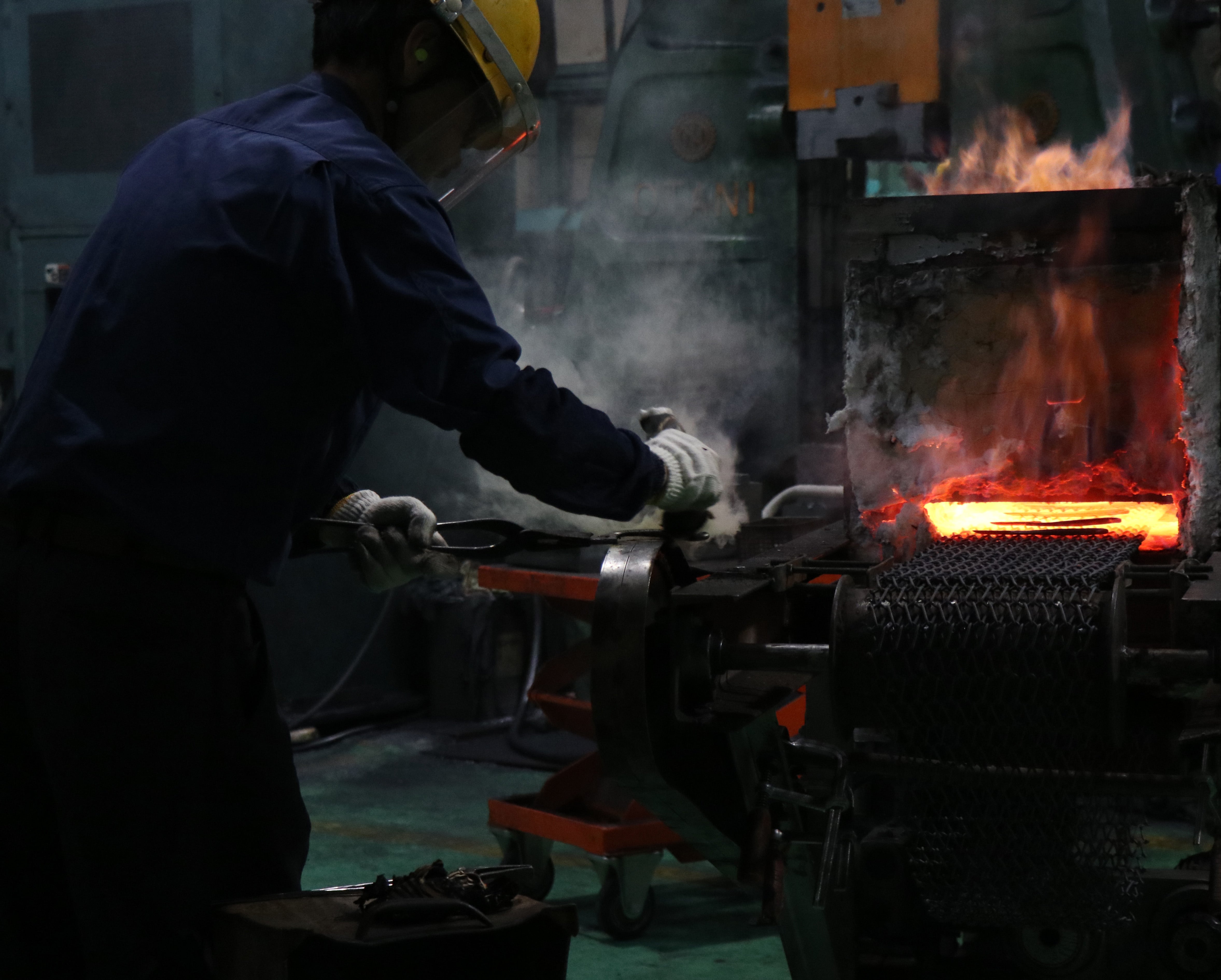 Toyama Hamono worker in protective gear using tongs