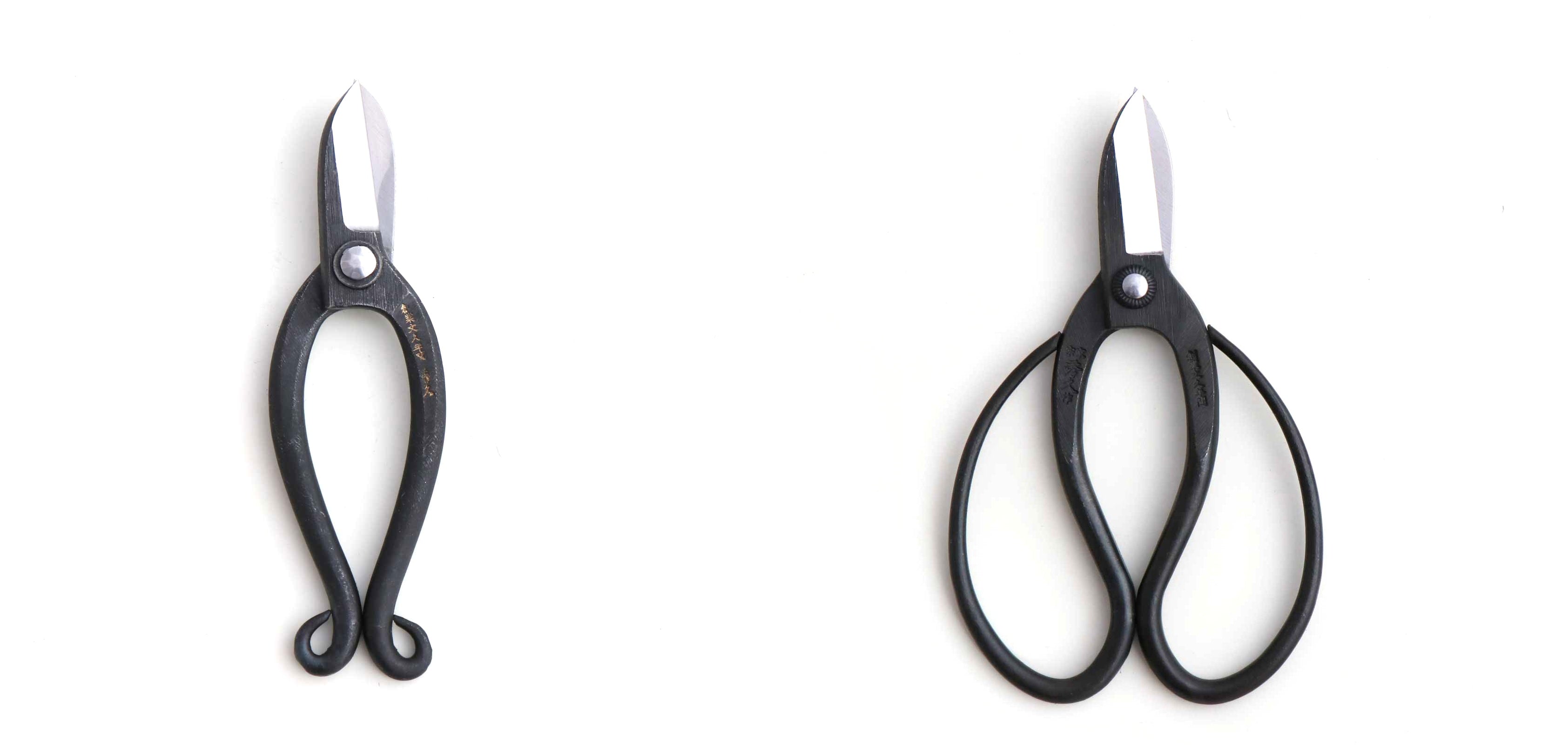 Two pairs of black-handled shears on a white background